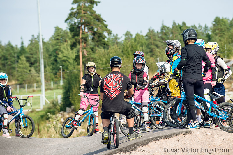 BMX-pyöräilijät kokoontuvat kuulemaan radan turvallisuusohjeista.